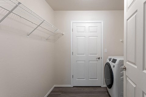 a white closet with a white door and a washing machine