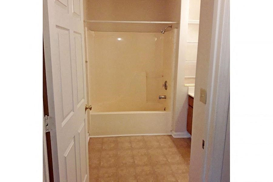 a bathroom with a shower and a white door