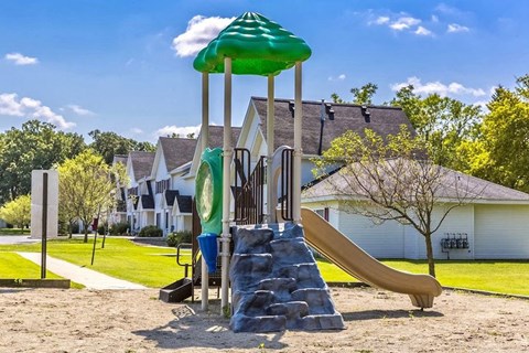 a playground with a slide and a umbrella