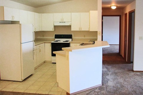 an empty kitchen with a stove and a refrigerator