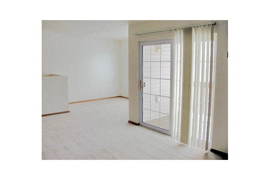 an empty living room with a glass door