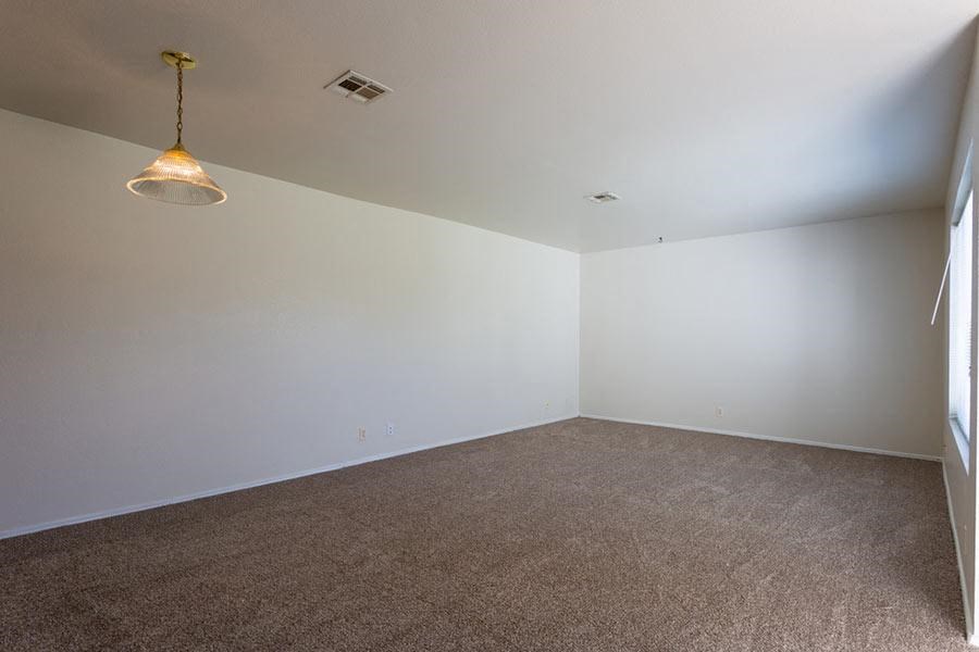 an empty room with white walls and a ceiling lamp