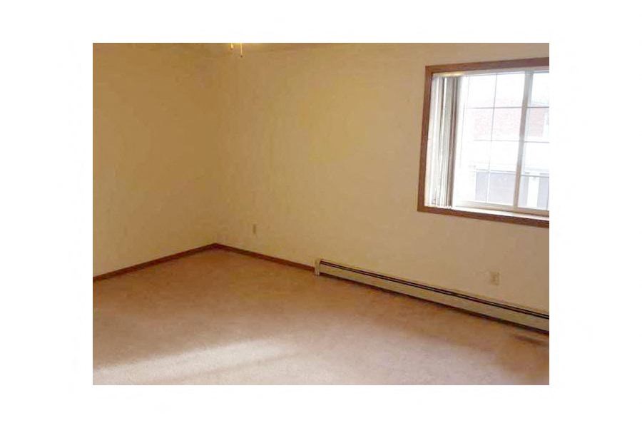 an empty room with a window and a carpet