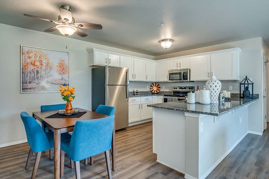 A kitchen with a table and chairs and a fridge.