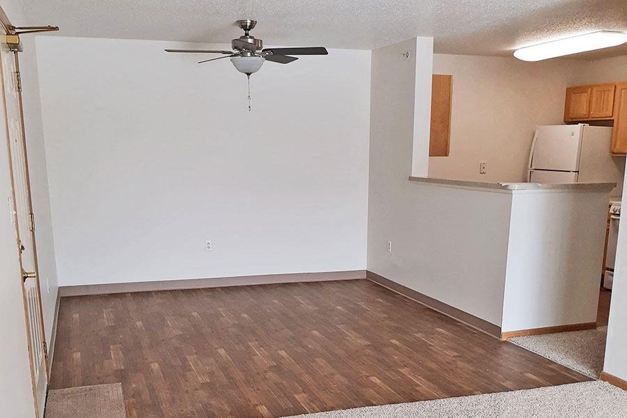 an empty room with a white wall and a ceiling fan