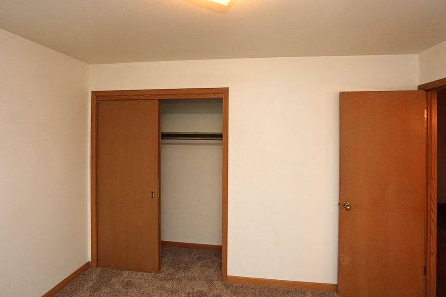 an empty room with a door to a closet