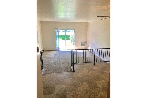 an empty living room with a railing