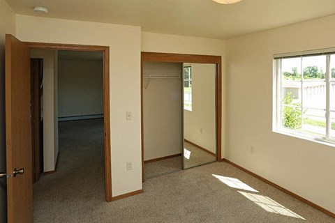 an empty room with a mirror and a closet