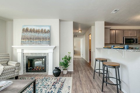 a living room with a fireplace and a bar with stools