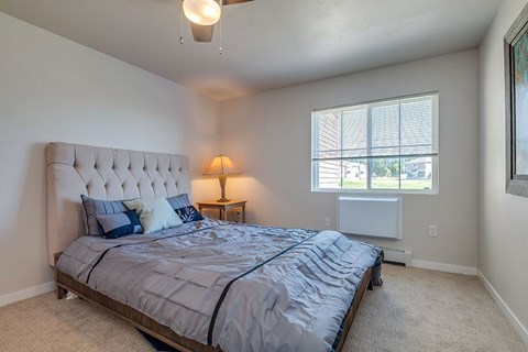 A bedroom with a large bed and a ceiling fan.