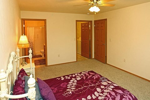 a bedroom with a bed and a ceiling fan