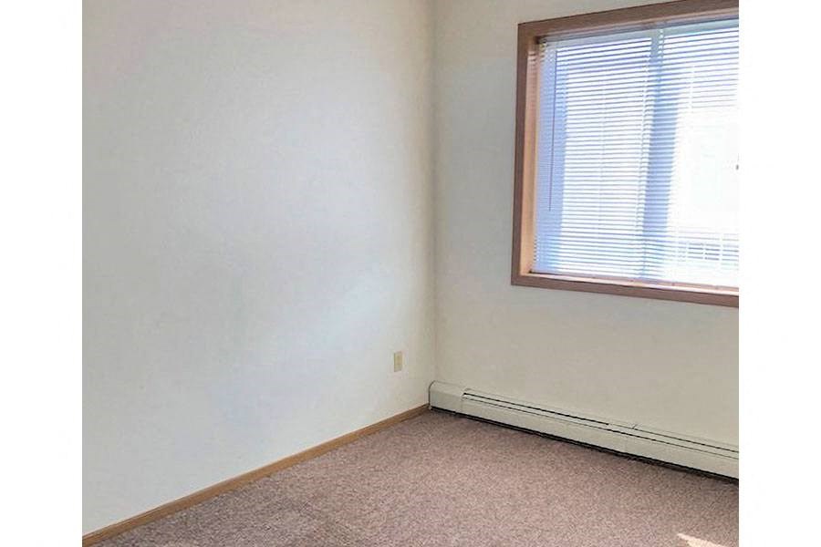 an empty room with a window and a white wall