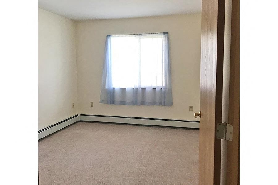 an empty room with a window and a door