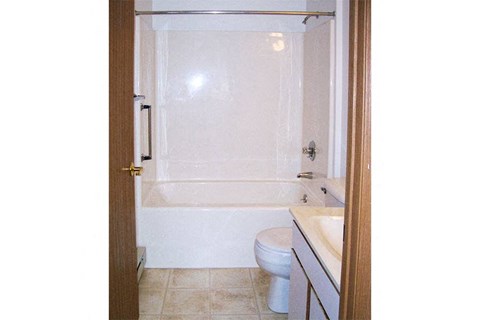 a bathroom with a toilet and a tub and a sink