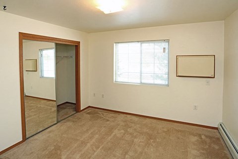 an empty room with a mirror and a window