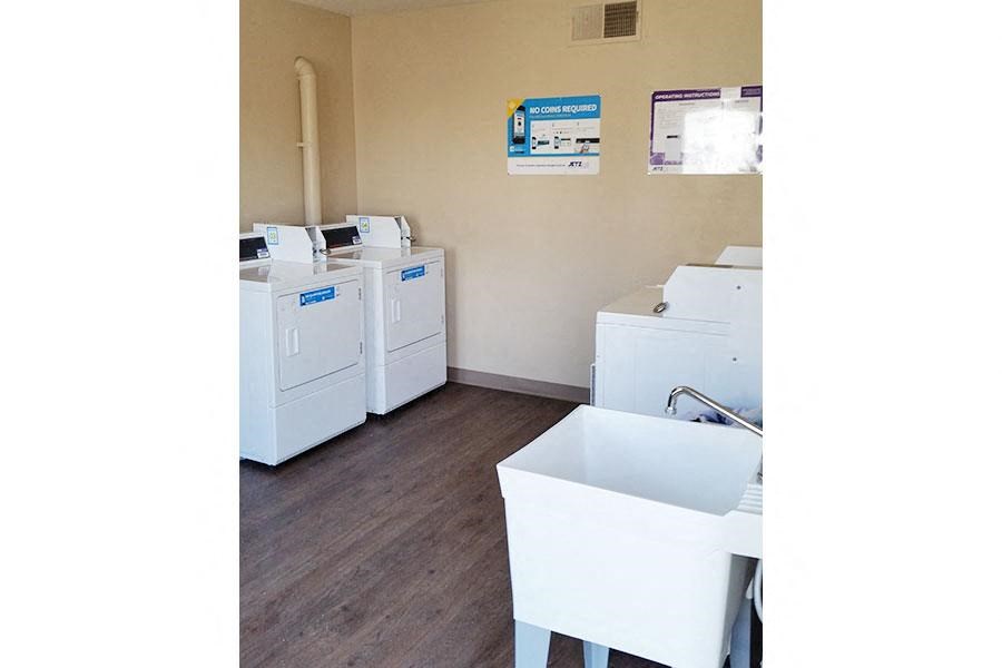 a room filled with white washing machines and sinks