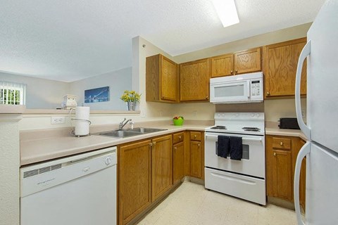 a kitchen with white appliances and wooden cabinets