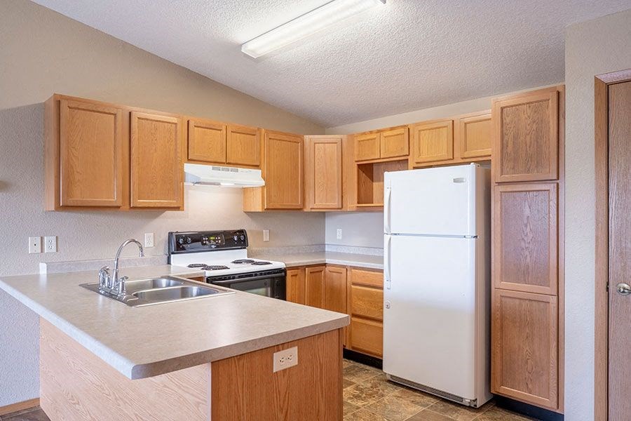 a kitchen with wooden cabinets and a white refrigerator