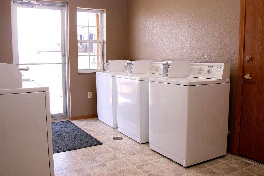 three washing machines in a room with a door