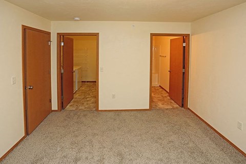 a empty room with three doors and a carpet floor