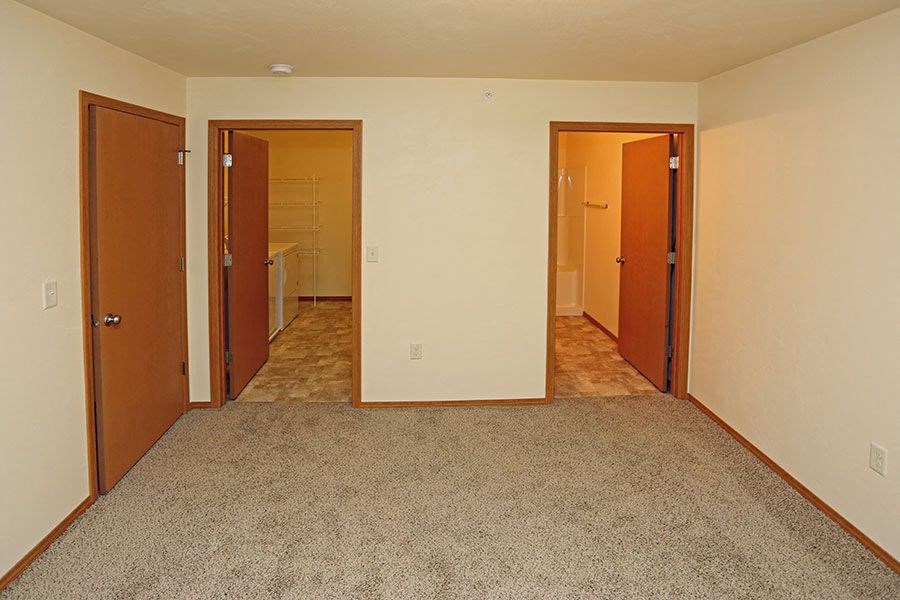 a empty room with three doors and a carpet floor