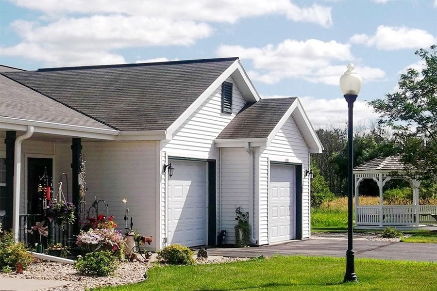 a white house with two garage doors and a street light