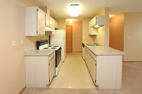 A kitchen with white appliances and cabinets.