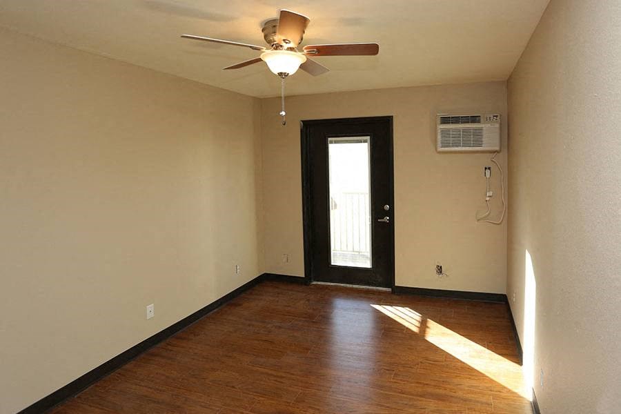 A room with a ceiling fan and a door.