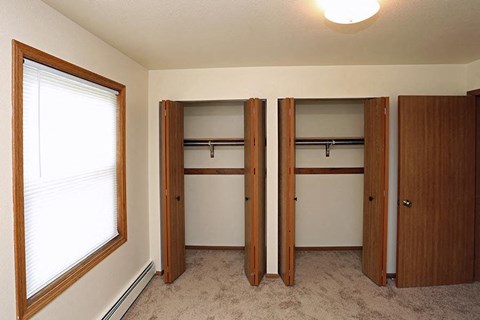 Closet with three doors and a window.