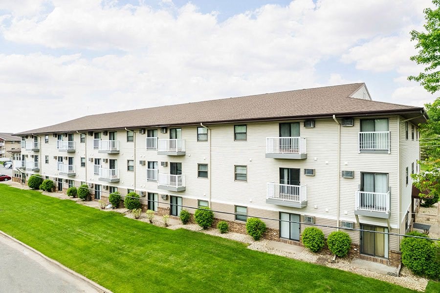 Apartment building with a brown roof and white walls.