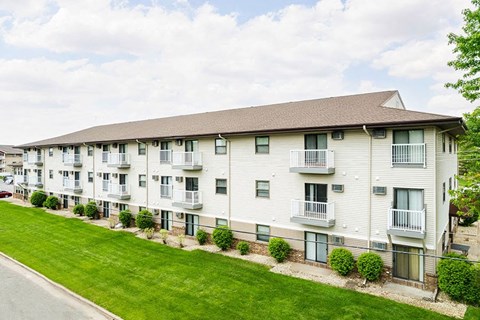 Apartment building with a brown roof and white walls.