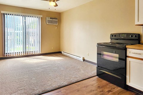 A kitchen with a black oven and a fan on the ceiling.