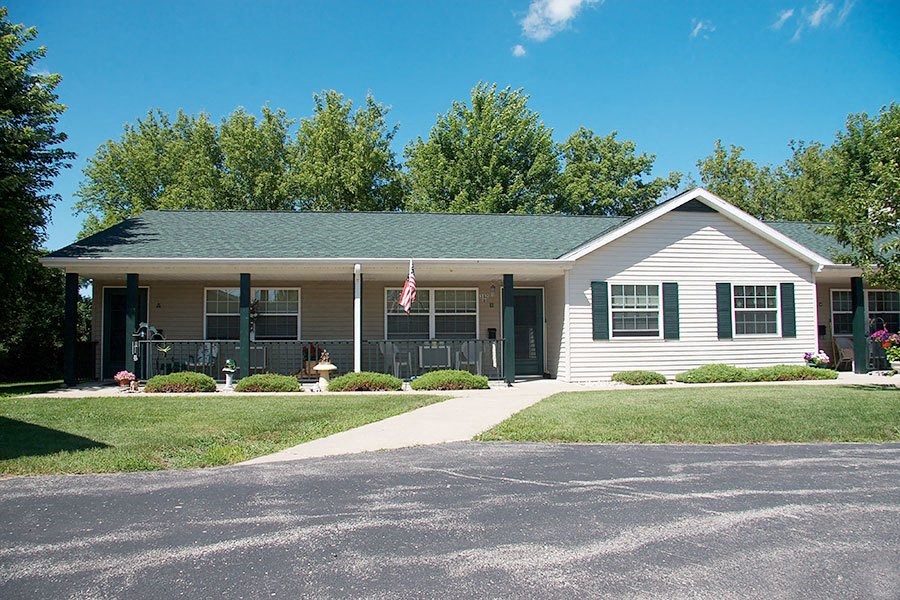 a white house with green shutters and a lawn