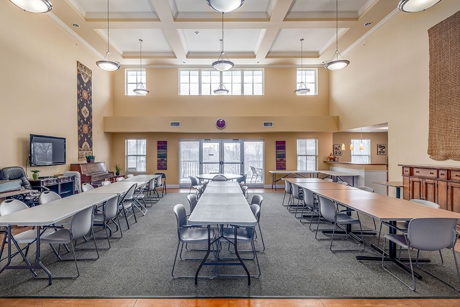 A large room with tables and chairs is empty.