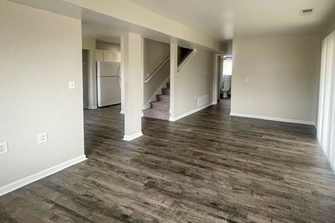 A spacious room with a staircase leading to another floor.