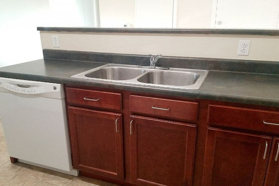 a kitchen with a sink and a white dishwasher