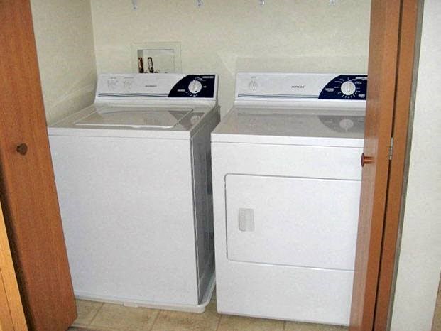 a white washer and dryer in a room with a door