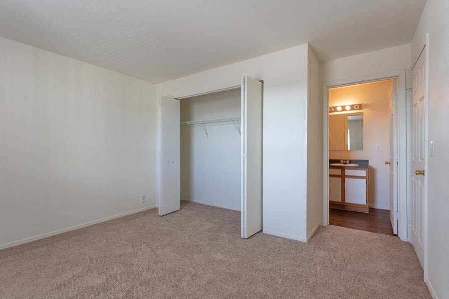 an empty bedroom with a closet and a bathroom