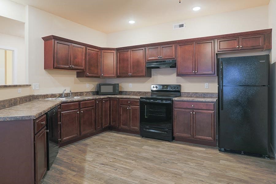 a large kitchen with black appliances and wooden cabinets