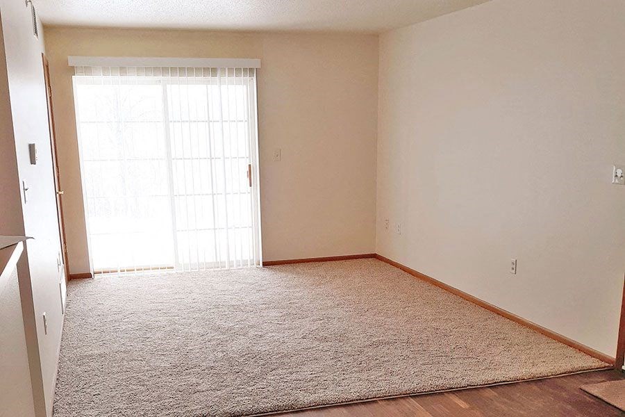 an empty room with a door and a carpet
