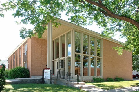 a building with large windows and a tree in front of it