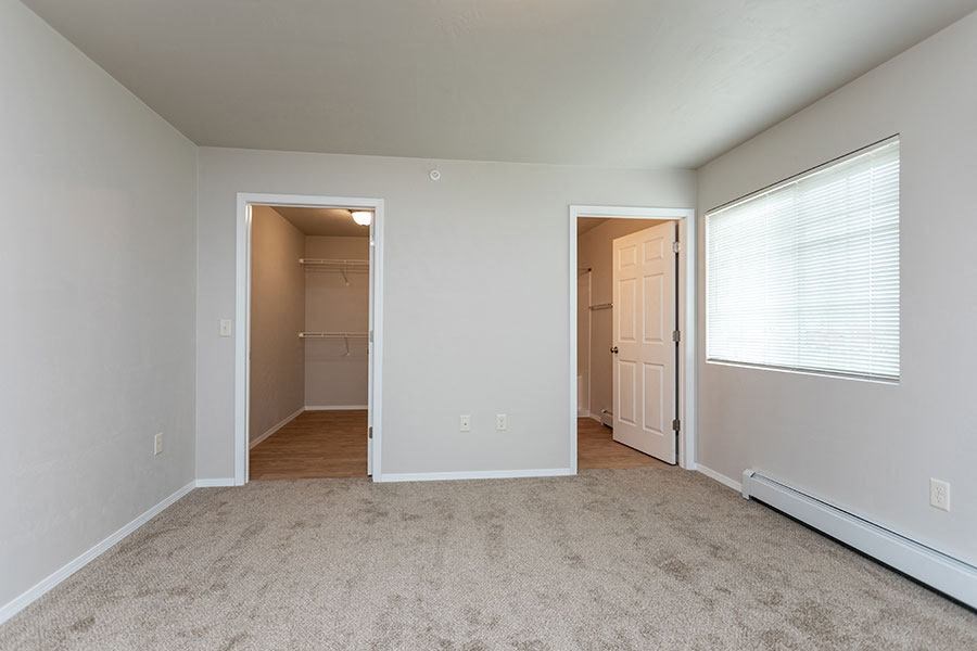 an empty living room with a door to a closet