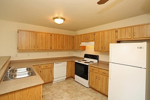 a kitchen with white appliances and wooden cabinets