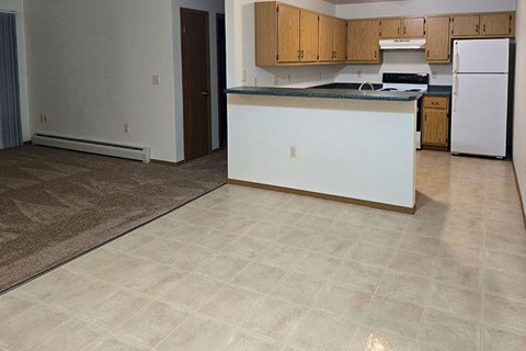 A kitchen with white appliances and wooden cabinets.