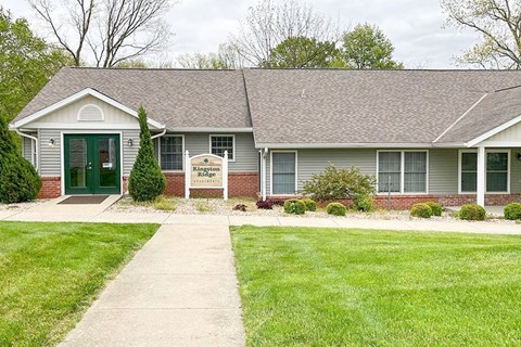 a white house with a green door and a lawn