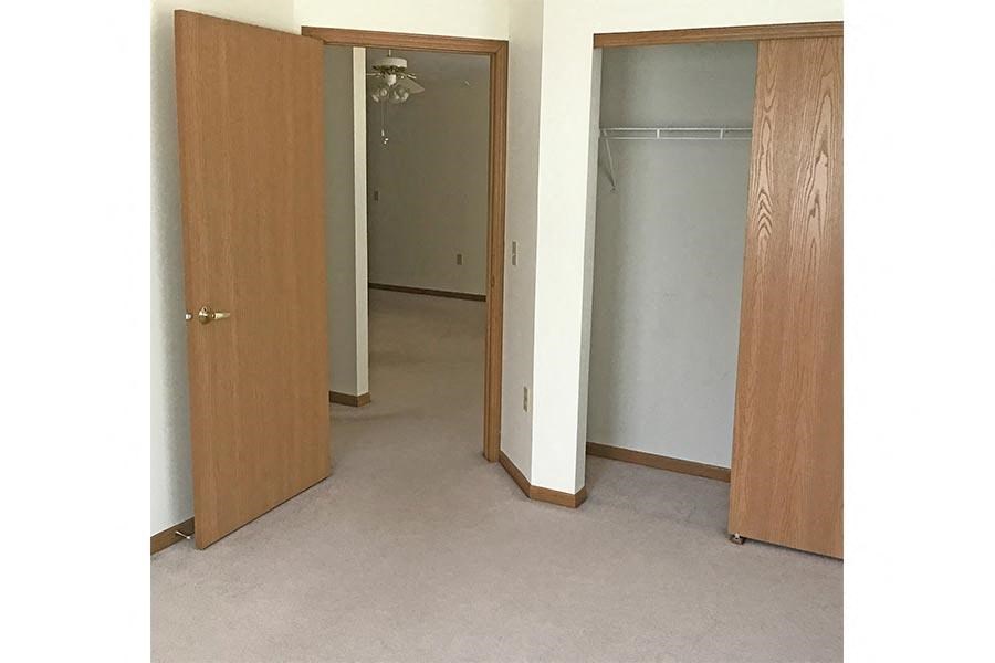 an empty room with a closet and two doors