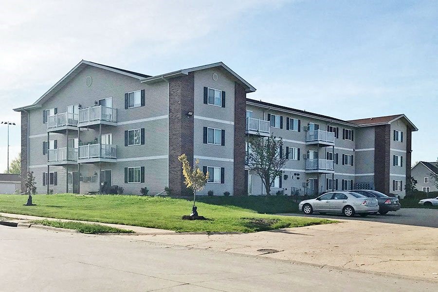 an apartment building with cars parked in front of it