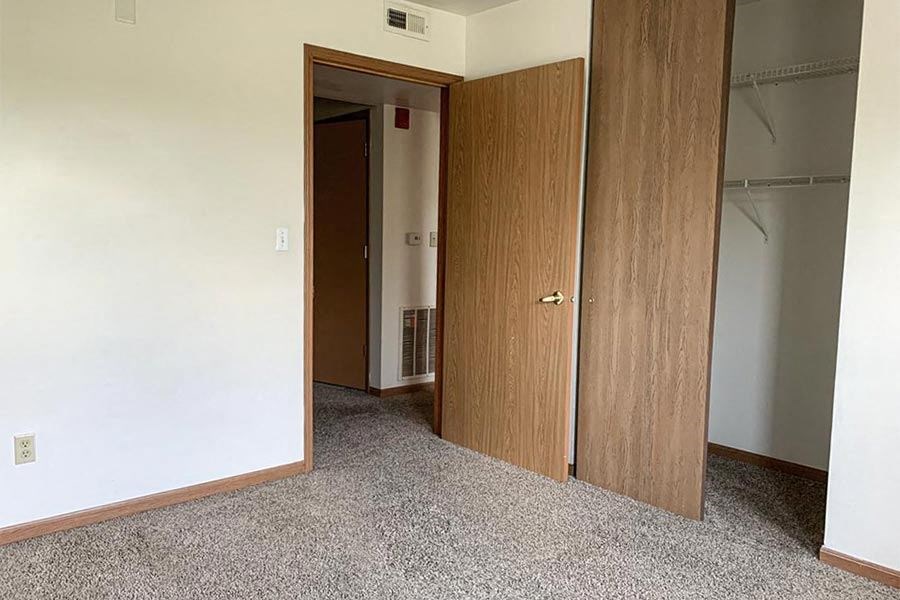 an empty room with two doors and a closet