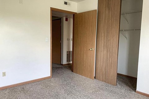 an empty room with two doors and a closet