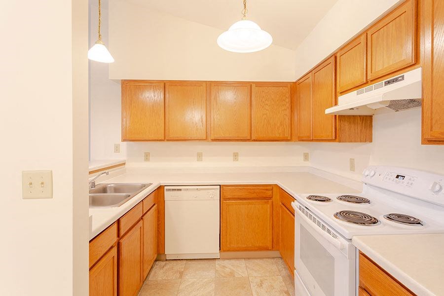 a kitchen with white appliances and wooden cabinets